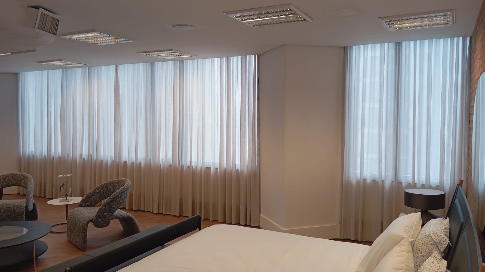 Suite com cortinas de voil instaladas pela Vagner Decor